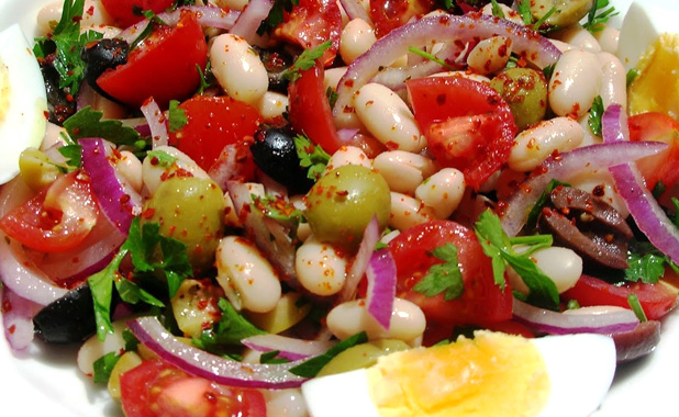 Bean salad with olives, fresh parsley and onions